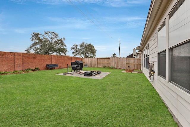 view of yard with a fenced backyard and a fire pit