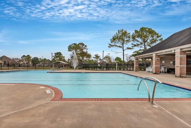 community pool with a patio and fence