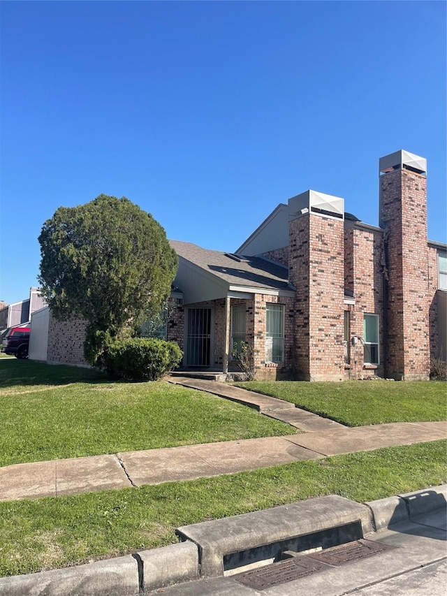 view of front of home featuring brick siding and a front lawn