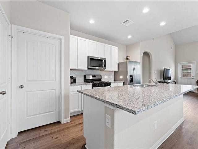 kitchen featuring white cabinets, a kitchen island with sink, and stainless steel appliances