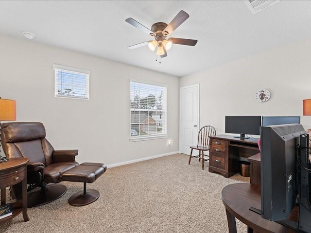 office space featuring light carpet, visible vents, a ceiling fan, and baseboards