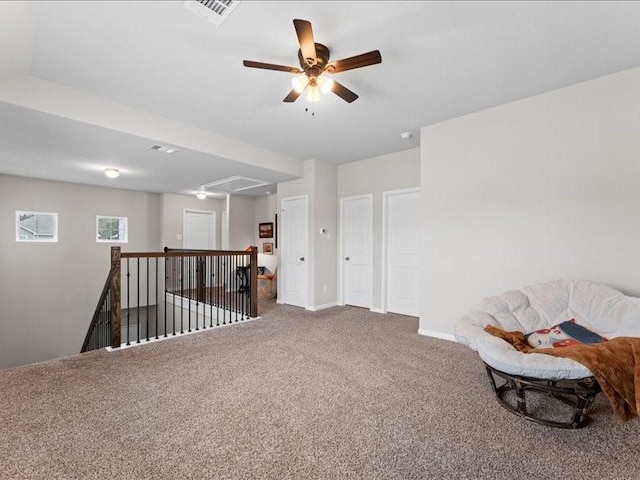 sitting room with visible vents, an upstairs landing, baseboards, carpet, and attic access