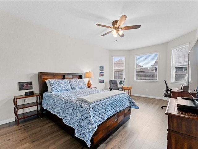 bedroom with a ceiling fan, baseboards, and wood finished floors