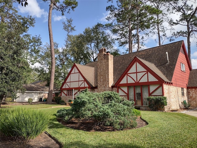 tudor home featuring a front lawn and roof with shingles