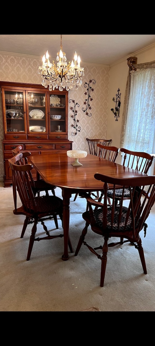 dining space with wallpapered walls, a notable chandelier, light colored carpet, and ornamental molding