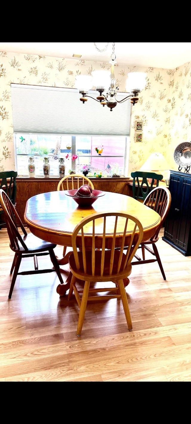 dining area featuring wallpapered walls, an inviting chandelier, and light wood finished floors