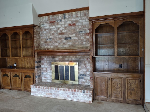 unfurnished living room featuring light colored carpet and a brick fireplace