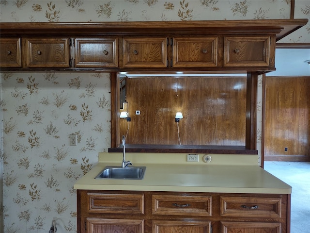 interior space featuring wallpapered walls, light countertops, and a sink