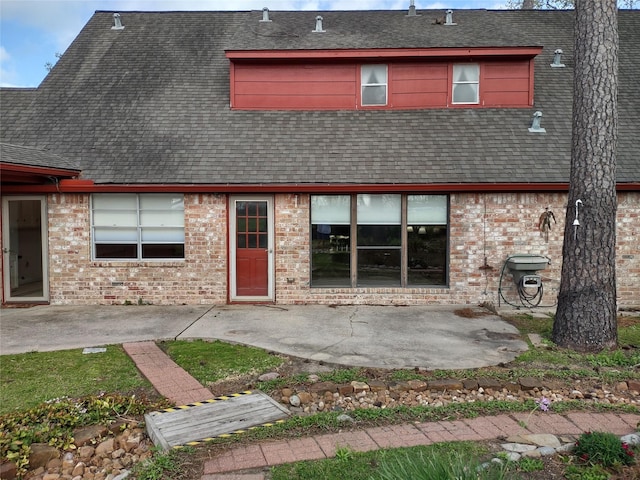 back of house featuring a patio, brick siding, and roof with shingles