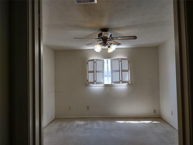 unfurnished room with a textured ceiling, visible vents, carpet floors, and ceiling fan