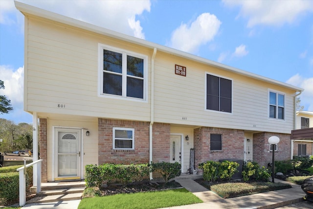 townhome / multi-family property with central air condition unit and brick siding