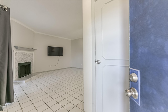 unfurnished living room with light tile patterned floors, ornamental molding, and a tile fireplace