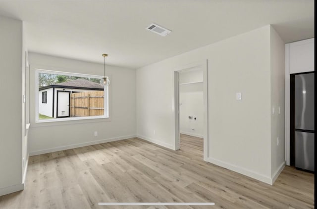 unfurnished dining area with baseboards, visible vents, and light wood finished floors