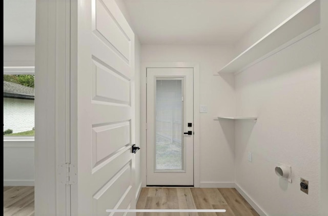 clothes washing area featuring laundry area, baseboards, light wood-style floors, and electric dryer hookup