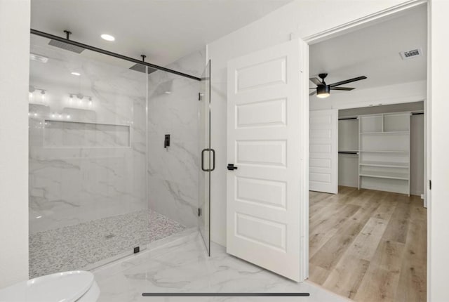 full bath with a walk in closet, marble finish floor, a marble finish shower, visible vents, and ceiling fan