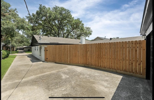 view of property exterior featuring a patio and fence