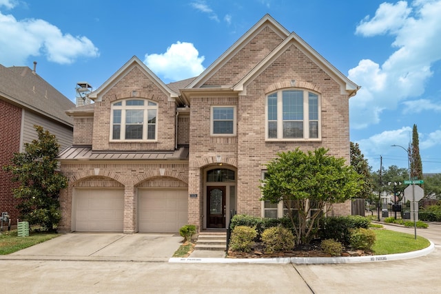 traditional-style home featuring a standing seam roof, brick siding, driveway, and an attached garage