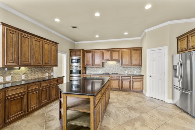 kitchen featuring a kitchen island, visible vents, stainless steel appliances, and crown molding