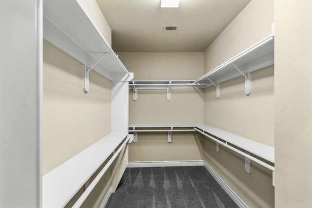 walk in closet with visible vents and dark colored carpet