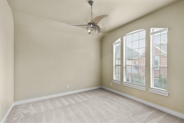 empty room featuring baseboards, a ceiling fan, and light colored carpet