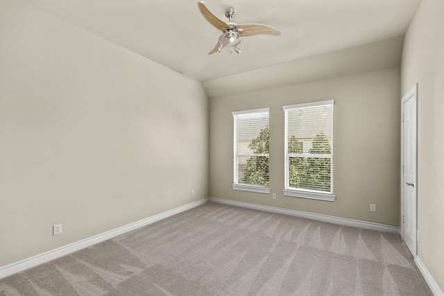 unfurnished room featuring baseboards, vaulted ceiling, a ceiling fan, and light colored carpet