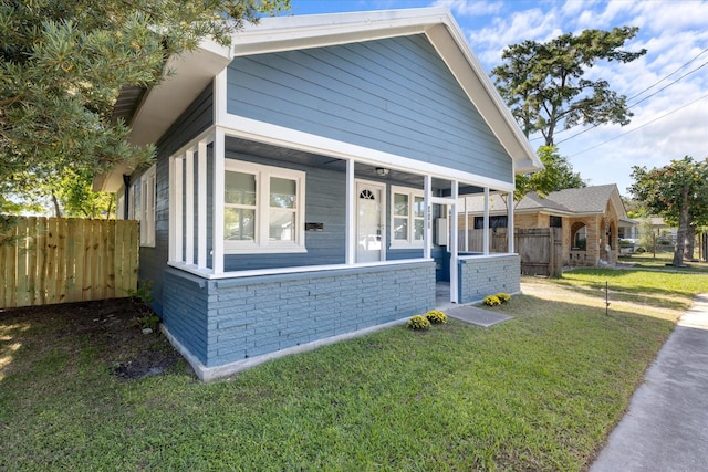 view of front of house featuring a front yard, fence, and brick siding