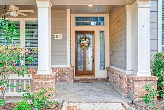 property entrance with brick siding and a ceiling fan