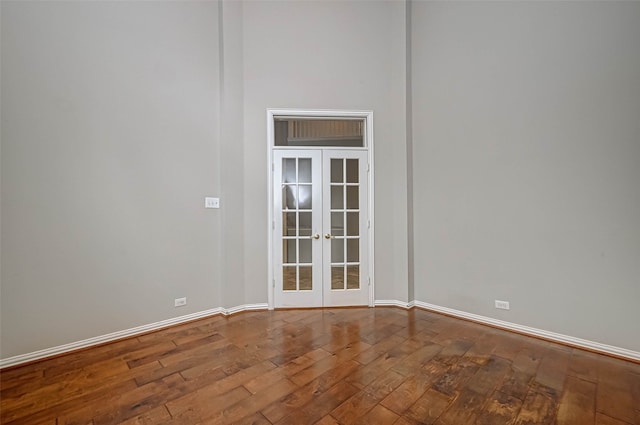 spare room with french doors, baseboards, and wood finished floors