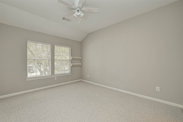 carpeted spare room featuring a ceiling fan, lofted ceiling, visible vents, and baseboards