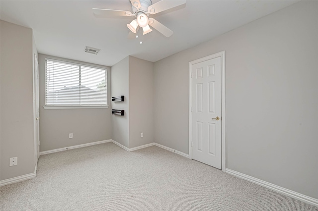 unfurnished room with visible vents, baseboards, a ceiling fan, and light colored carpet