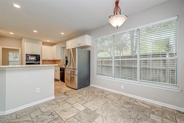 kitchen featuring baseboards, light stone counters, decorative light fixtures, black appliances, and white cabinetry