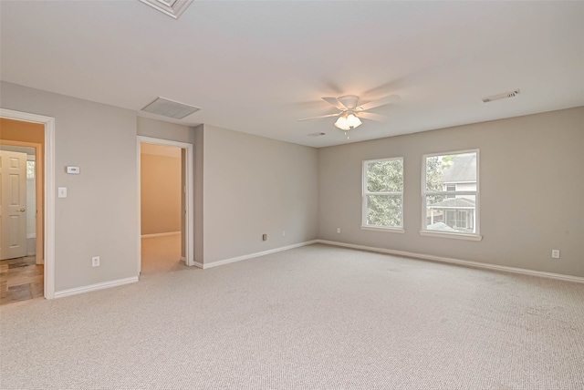 spare room featuring visible vents, light carpet, and baseboards