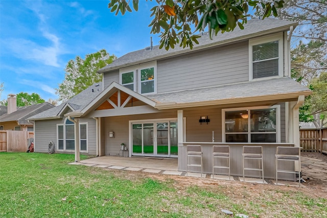 rear view of property with exterior bar, a lawn, a patio area, and fence