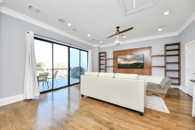 living room with baseboards, light wood-style flooring, visible vents, and crown molding