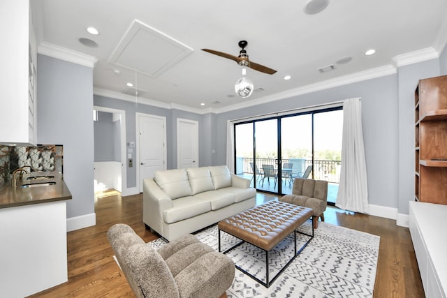 living room with visible vents, ornamental molding, dark wood-style flooring, and attic access