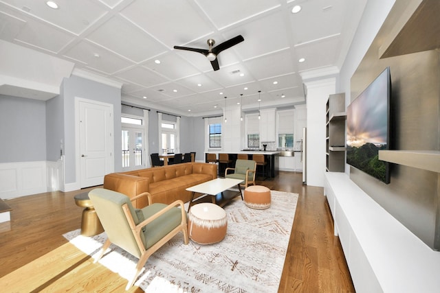 living area featuring light wood-type flooring, wainscoting, coffered ceiling, and recessed lighting