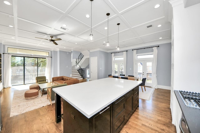 kitchen with french doors, decorative light fixtures, light countertops, open floor plan, and coffered ceiling