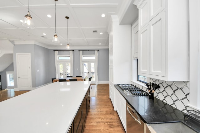 kitchen with coffered ceiling, dishwasher, white cabinets, decorative light fixtures, and french doors