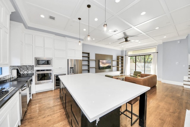 kitchen featuring visible vents, a large island, appliances with stainless steel finishes, open floor plan, and pendant lighting