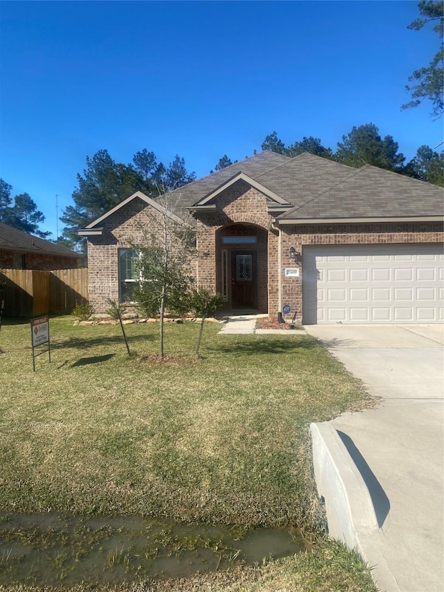 ranch-style house featuring driveway, a front yard, fence, and brick siding