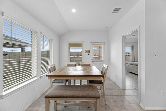 dining area featuring lofted ceiling, baseboards, visible vents, and light tile patterned flooring