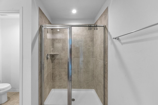 full bathroom featuring toilet, a shower stall, and tile patterned flooring