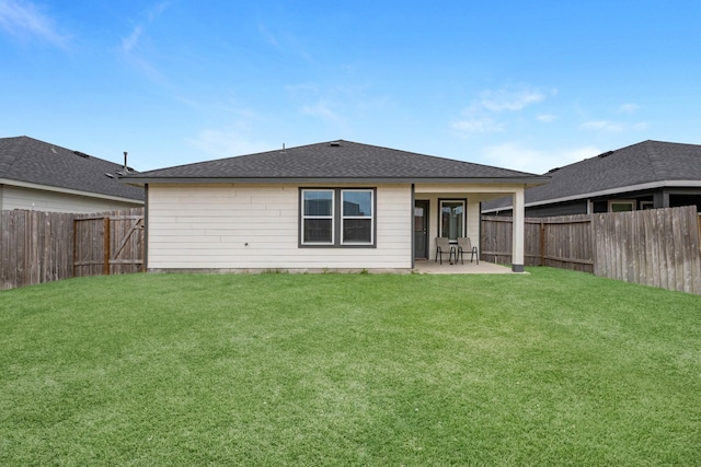 rear view of property featuring a patio area, a fenced backyard, a shingled roof, and a yard