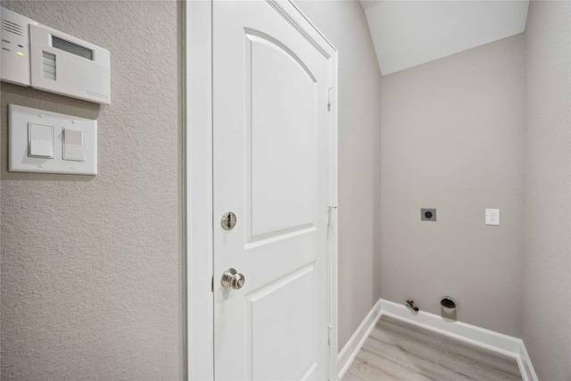 washroom featuring laundry area, baseboards, hookup for a gas dryer, light wood-type flooring, and electric dryer hookup