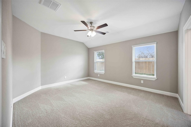 empty room with ceiling fan, carpet floors, visible vents, baseboards, and vaulted ceiling