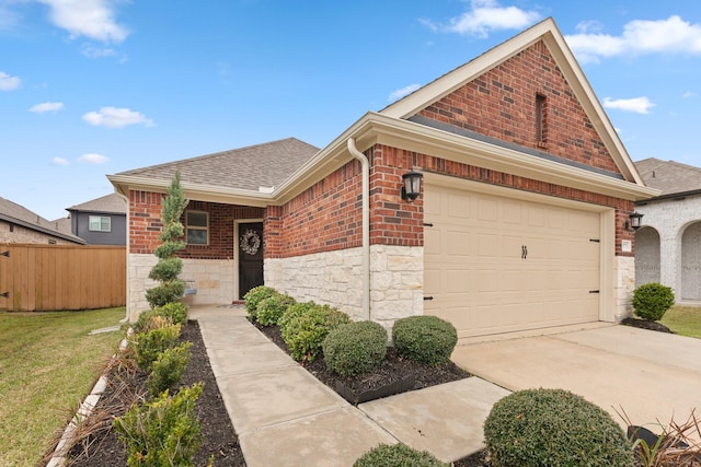 view of front facade featuring brick siding, a shingled roof, concrete driveway, fence, and a front yard