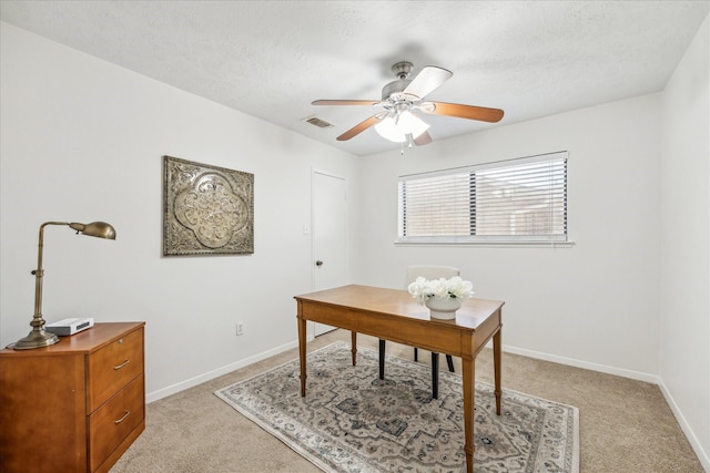 office featuring a textured ceiling, ceiling fan, visible vents, and baseboards