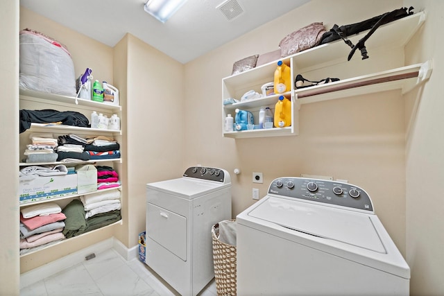 clothes washing area with laundry area, baseboards, visible vents, washing machine and clothes dryer, and marble finish floor