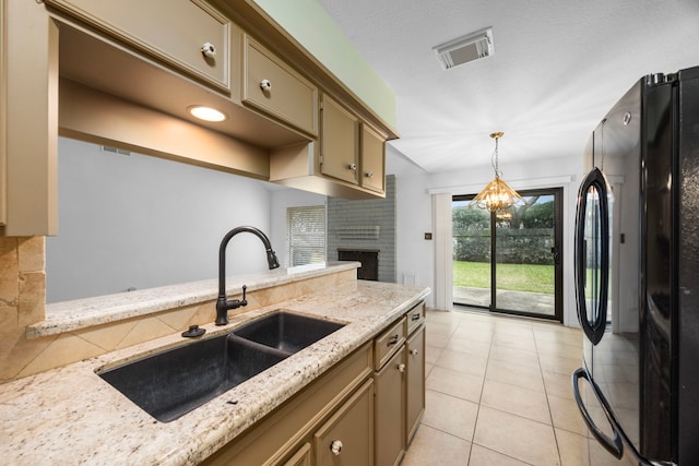 814 Pickford Dr, Katy, TX 77450 - kitchen featuring freestanding refrigerator, hanging light fixtures, light stone countertops, a brick fireplace, and light tile patterned floors