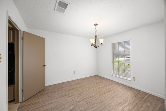 814 Pickford Dr, Katy, TX 77450 - unfurnished room featuring a chandelier, light wood-type flooring, and a textured ceiling